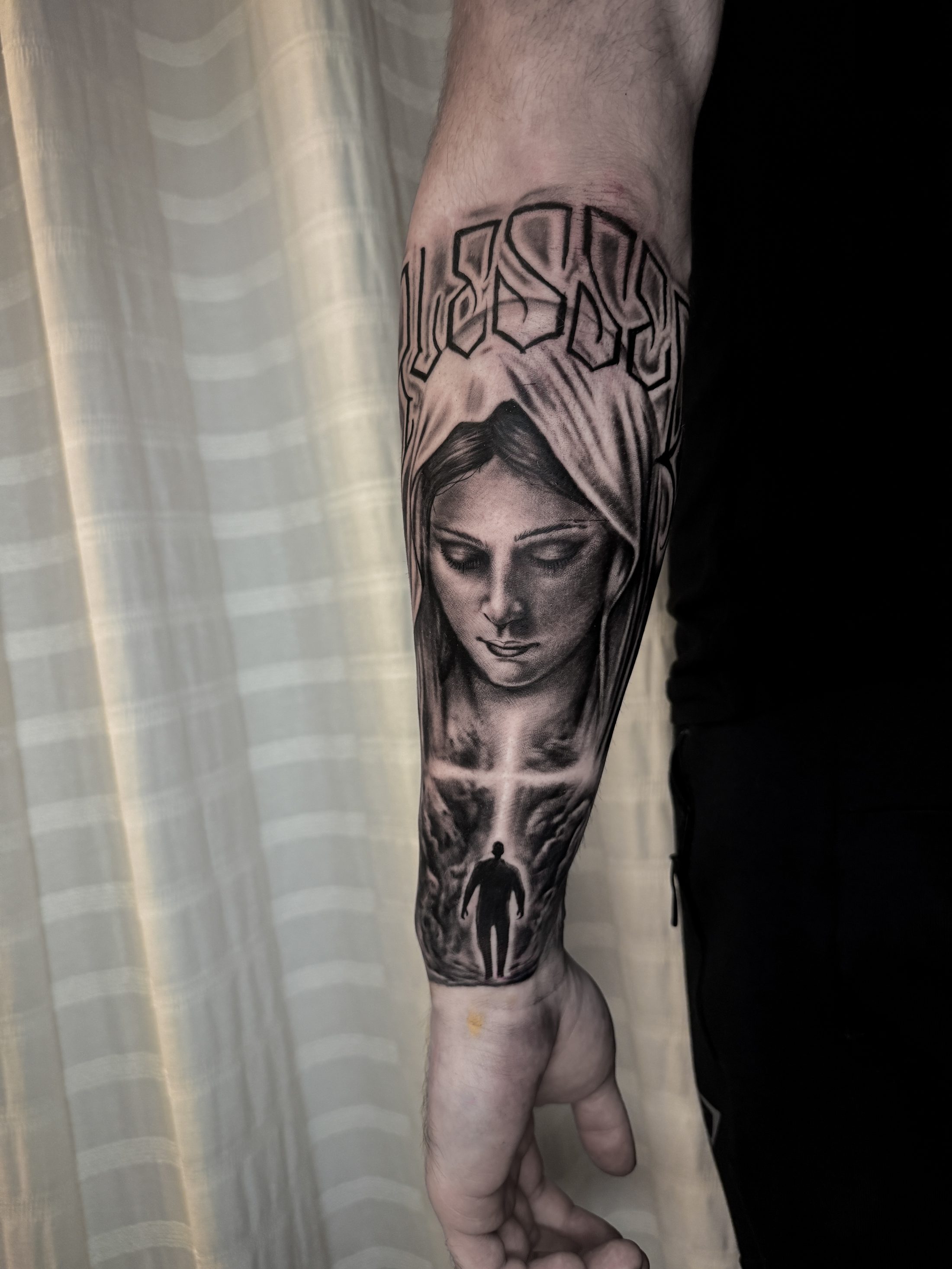 Jungfrau Maria mit Kreuz und Schriftzug auf dem Unterarm